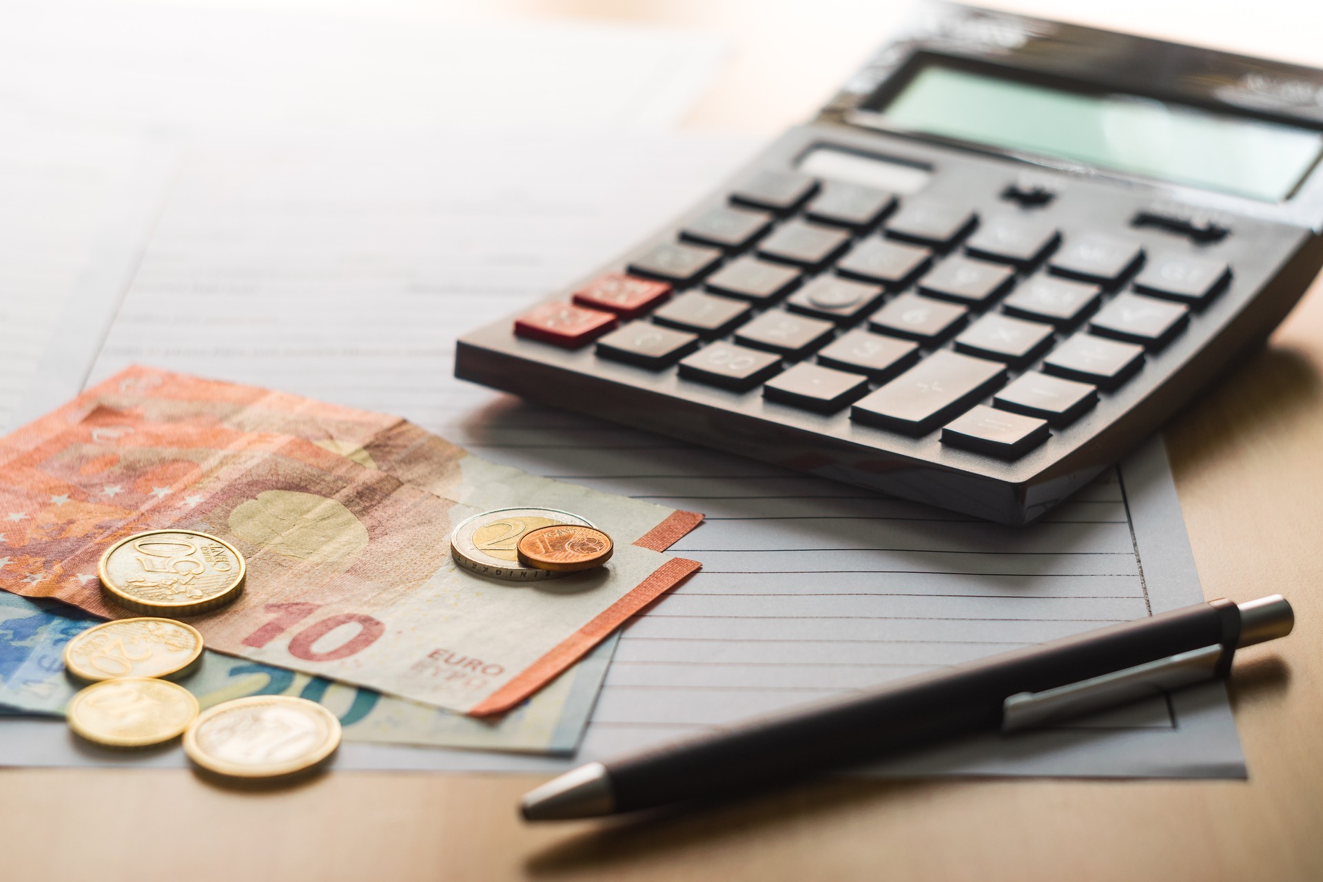 A calculator, coins and tax forms on the table to reckon